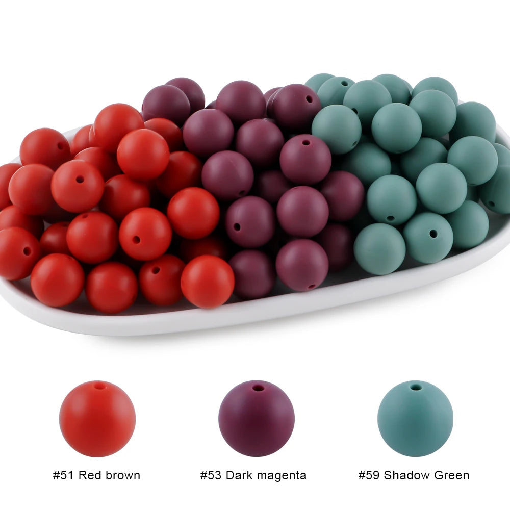 A collection of round silicone beads in various shades including red, maroon, and green.