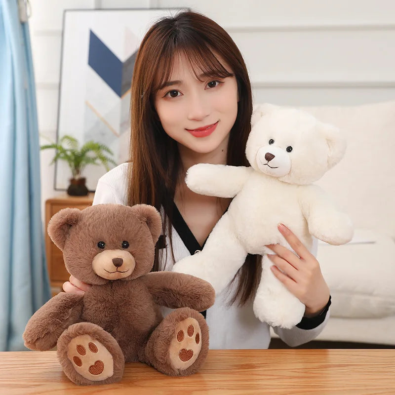 A woman holds a fluffy white teddy bear plush pillow with a bow on a wooden table.
