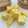 Yellow cheese dice cubes and a carrying case are displayed on a white surface.