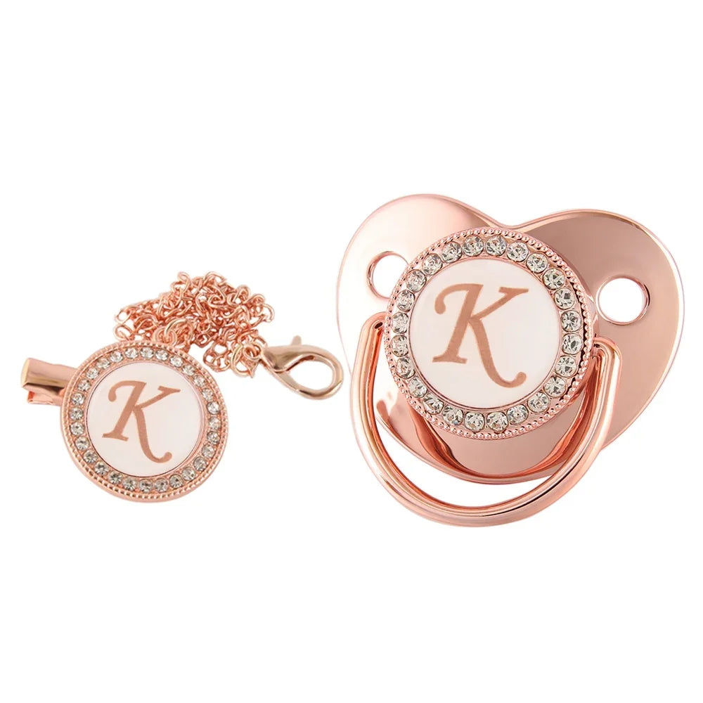 Rose gold bling baby pacifier clip featuring a silicone holder and a decorative K charm