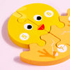 A yellow wooden puzzle piece shaped like a cartoon dinosaur, featuring numbers 5 and 6.
