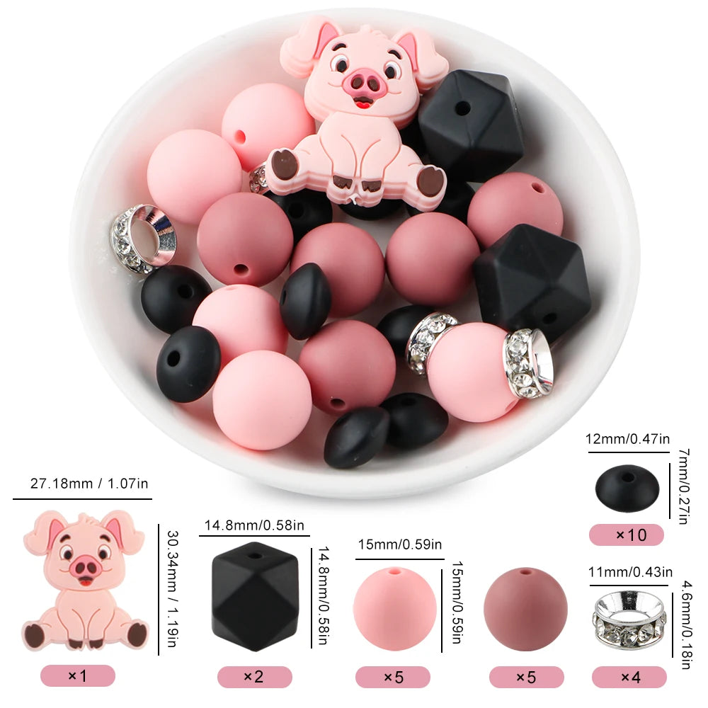 A variety of pink and black silicone beads shaped like a pig are displayed in a white bowl with usage instructions.