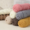 A collection of skeins of pink, white, gray, brown, and yellow premium milk cotton knitting yarn.