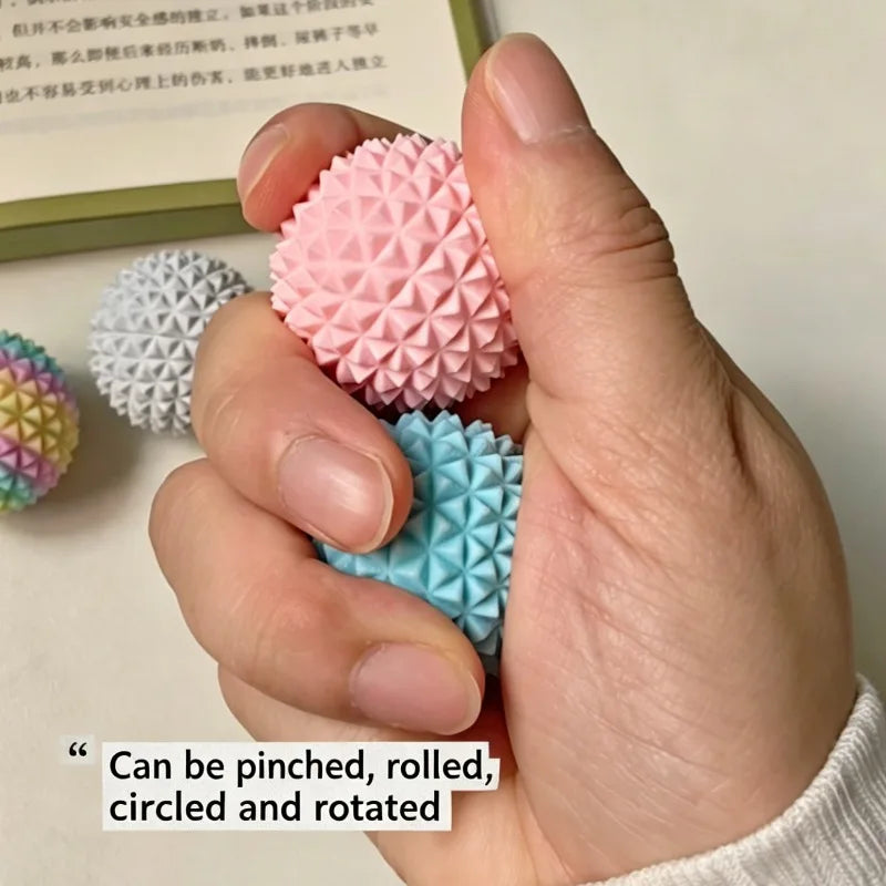 A hand holds a pink, spiky 3D printed sensory fidget roller for stress relief.