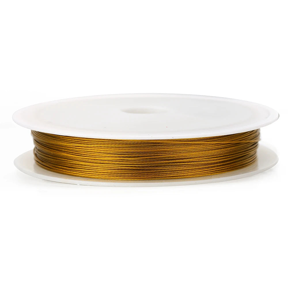 A spool of gold-colored stainless steel beading wire for jewelry making resting on a white circular disc.