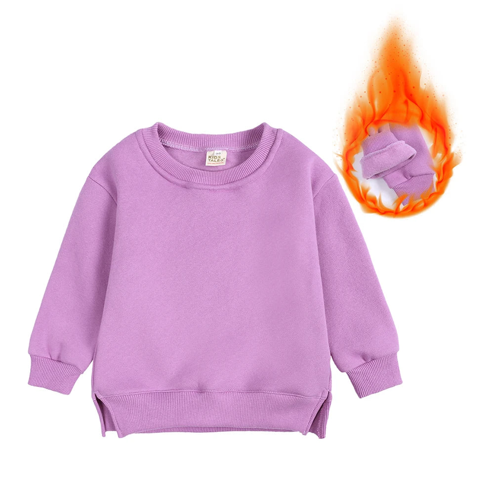 A light purple kids pullover hoodie with a small tag and a bundle of orange flame nearby.