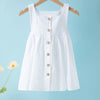 White summer cotton linen jumper dress for toddler girls hanging on a wooden hanger against a light blue background