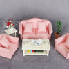 A pink 1:12 scale mini sofa and pillow set for a dollhouse displayed on a gray surface.