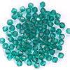 A cluster of small, faceted, teal green bicone glass beads for jewelry making.