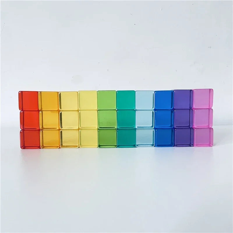 A row of colorful rainbow acrylic building blocks arranged horizontally.