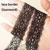 Close-up of black lace border shoelaces being held by a hand