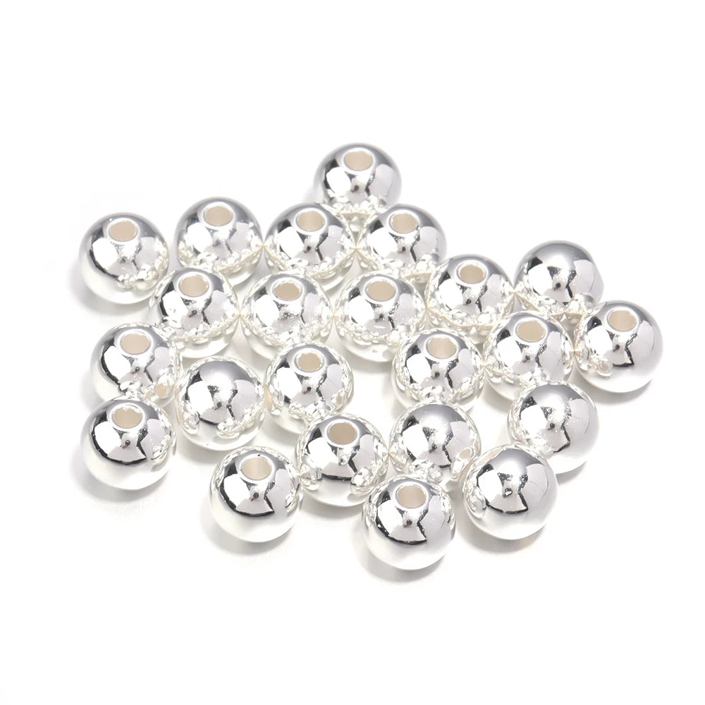 A cluster of small, silver-toned imitation pearl beads for DIY jewelry making.