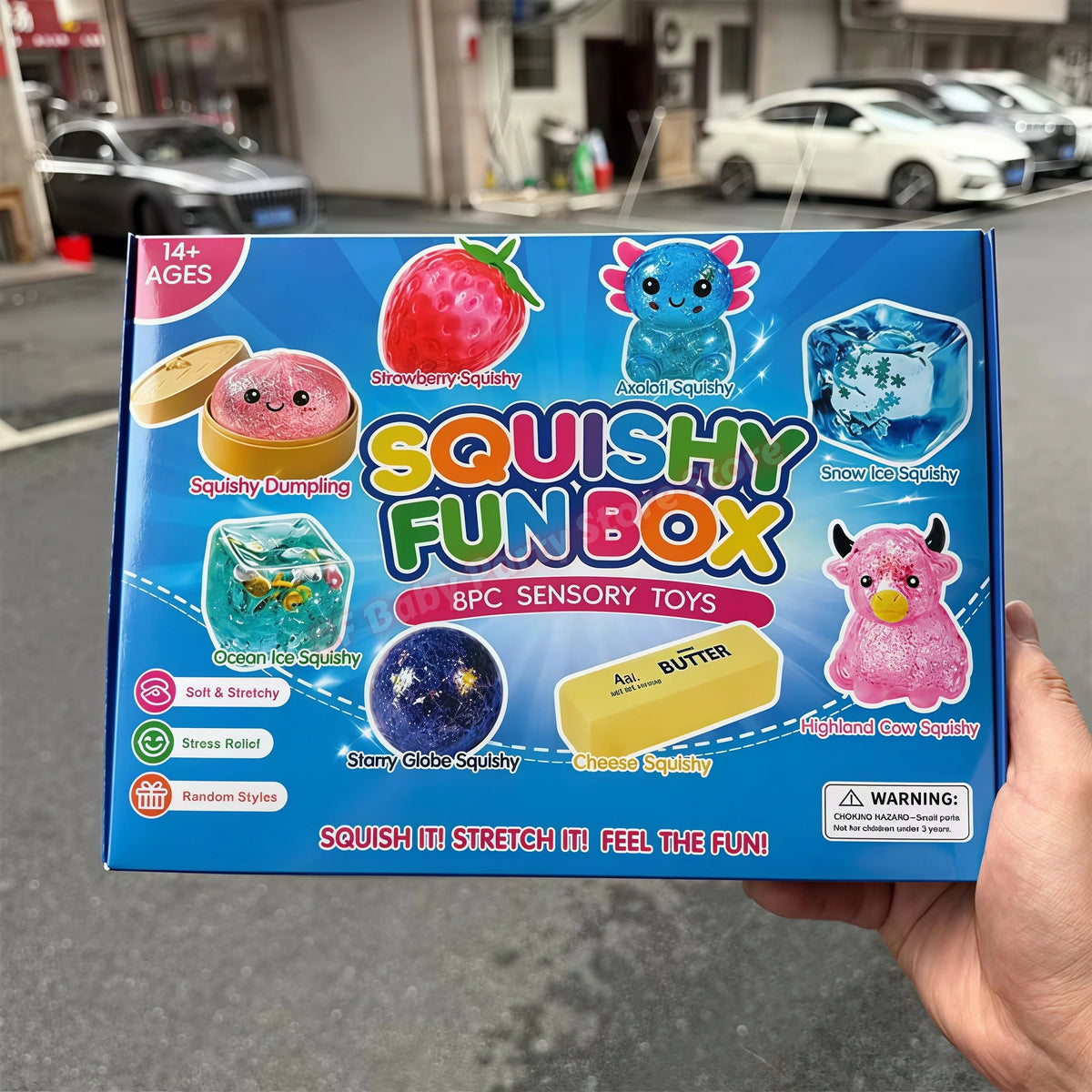 A box of Squishy Fun Box sensory toys featuring various squishy items like strawberry, ice, and butter.
