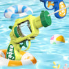 A yellow mini water blaster pistol is spraying water toward a floating inflatable ring and a ball in blue water.