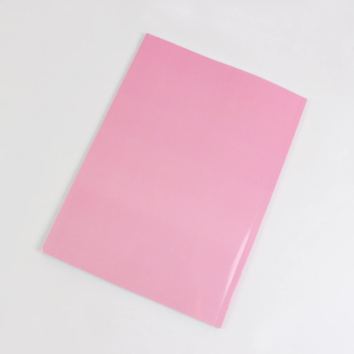 A pink booklet titled Step-by-Step Drawing Guide for Beginners lying on a white surface.