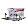 A display case showing a 1:64 scale two-story car showroom and parking garage model.