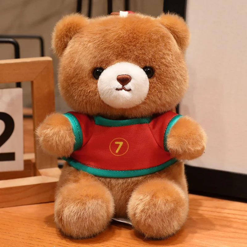 A fluffy brown teddy bear wearing a red and green football jersey with the number 7.