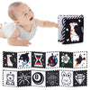 A baby is shown next to a set of black and white sensory cloth book pages featuring various animal and object illustrations.
