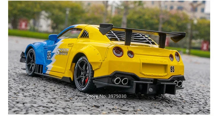 Yellow 1:24 scale diecast GTR sports car model with lights and sound on a gray asphalt surface.