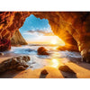 A jigsaw puzzle depicting a dramatic sunset view inside an orange cave opening onto the ocean.