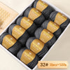A box of Merino wool yarn balls with yellow labels showing the weight and quantity.