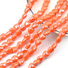 A string of small, orange heart-shaped acrylic beads for jewelry making.