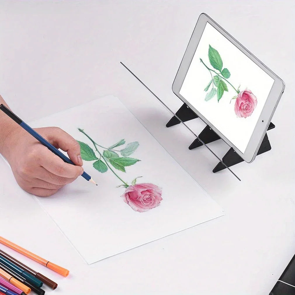 A hand draws a pink rose and leaves on white paper next to an Apple iPad drawing board.