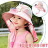 A young girl is wearing a pink solar fan hat outdoors, demonstrating the product.