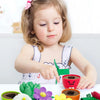 A child is interacting with a colorful sorting and stacking toy set featuring various plant-like shapes in different colored 