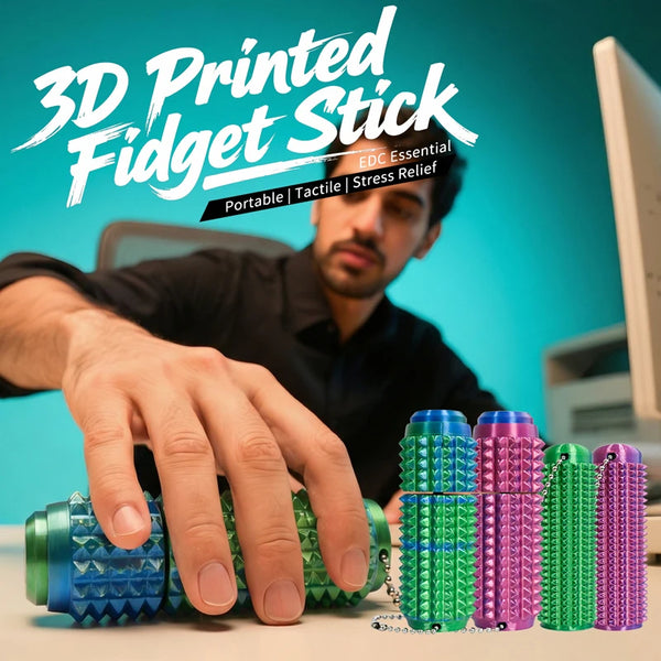 A hand holds a green spiky fidget stick keychain with purple and green accents on a desk.