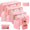 A set of pink travel packing cubes and storage bags for organizing items.