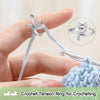 A hand is shown using a crochet tension ring to form an adjustable cat-ear crochet ring.