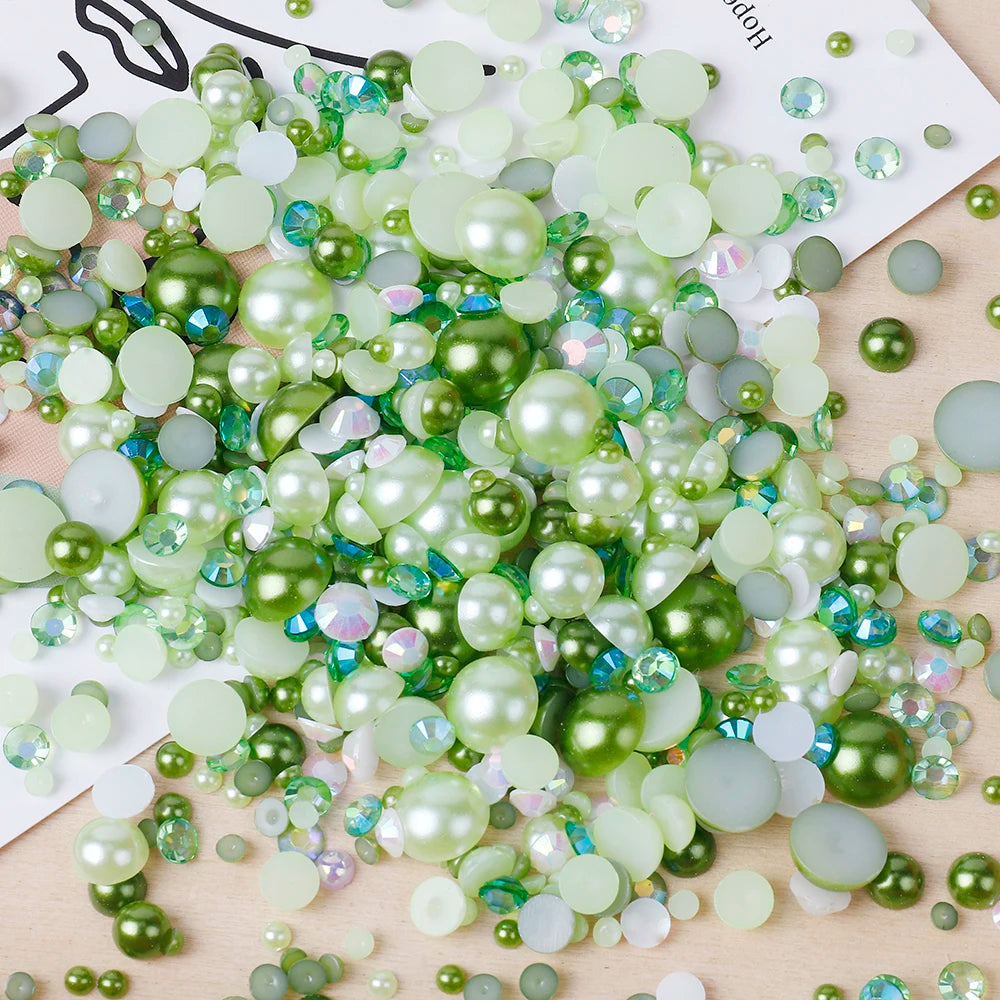 A pile of mixed resin rhinestone pearls in various shades of green and clear, iridescent colors for crafts and nail art.