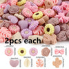 A collection of pink, purple, and yellow silicone flower and leaf beads for jewelry making.
