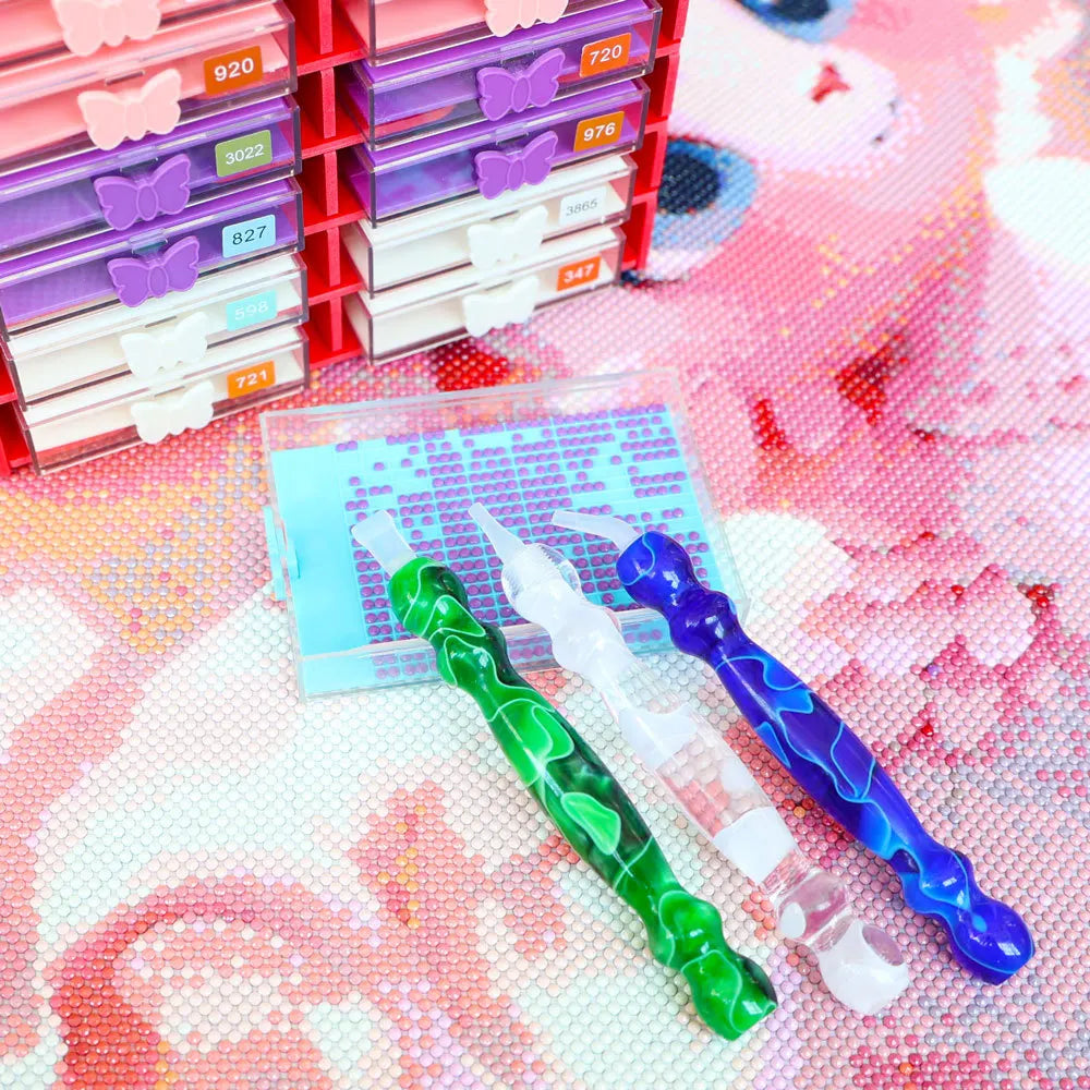 A set of diamond art pens with twelve interchangeable tips in various colors including green, white, and blue.