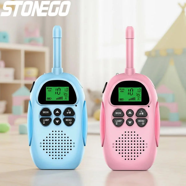A pair of pink and blue kids rechargeable walkie talkies sitting on a wooden surface.