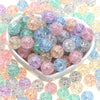 A bowl filled with various colored glitter cracked acrylic round beads for jewelry making