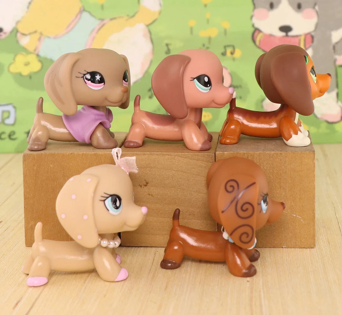 A set of three dachshund bobblehead figurines in various shades of brown and tan, displayed on a wooden block.