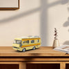 A yellow and orange RV model kit built from building blocks resting on a wooden table.