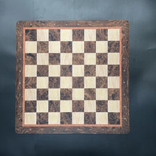 A large wooden chessboard with a checkered pattern and numbered lines, suitable for folding or tournament play.