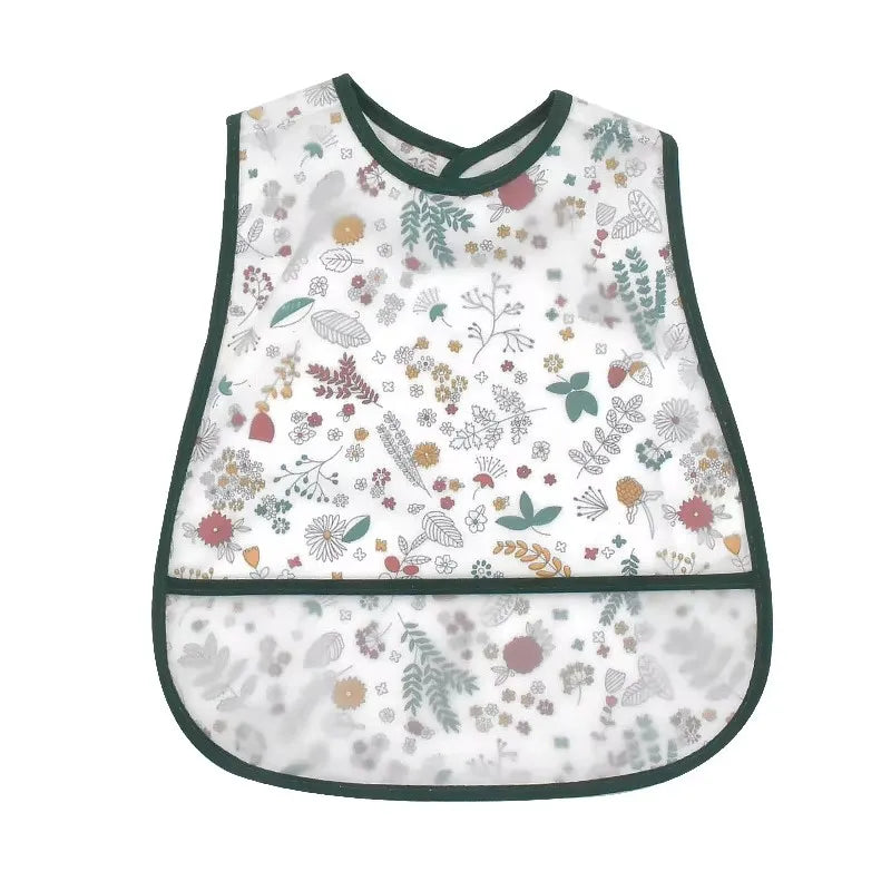 A white baby bib with a cartoon pattern featuring various floral and leaf designs.