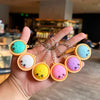 A hand holds a string of adorable dumpling stress relief keychains in various pastel colors like blue, yellow, and pink.