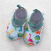 A pair of colorful baby barefoot water shoes featuring various dinosaur and animal patterns.