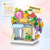 A LEGO building block set depicting a fruit shop storefront with signage and various fruit elements.