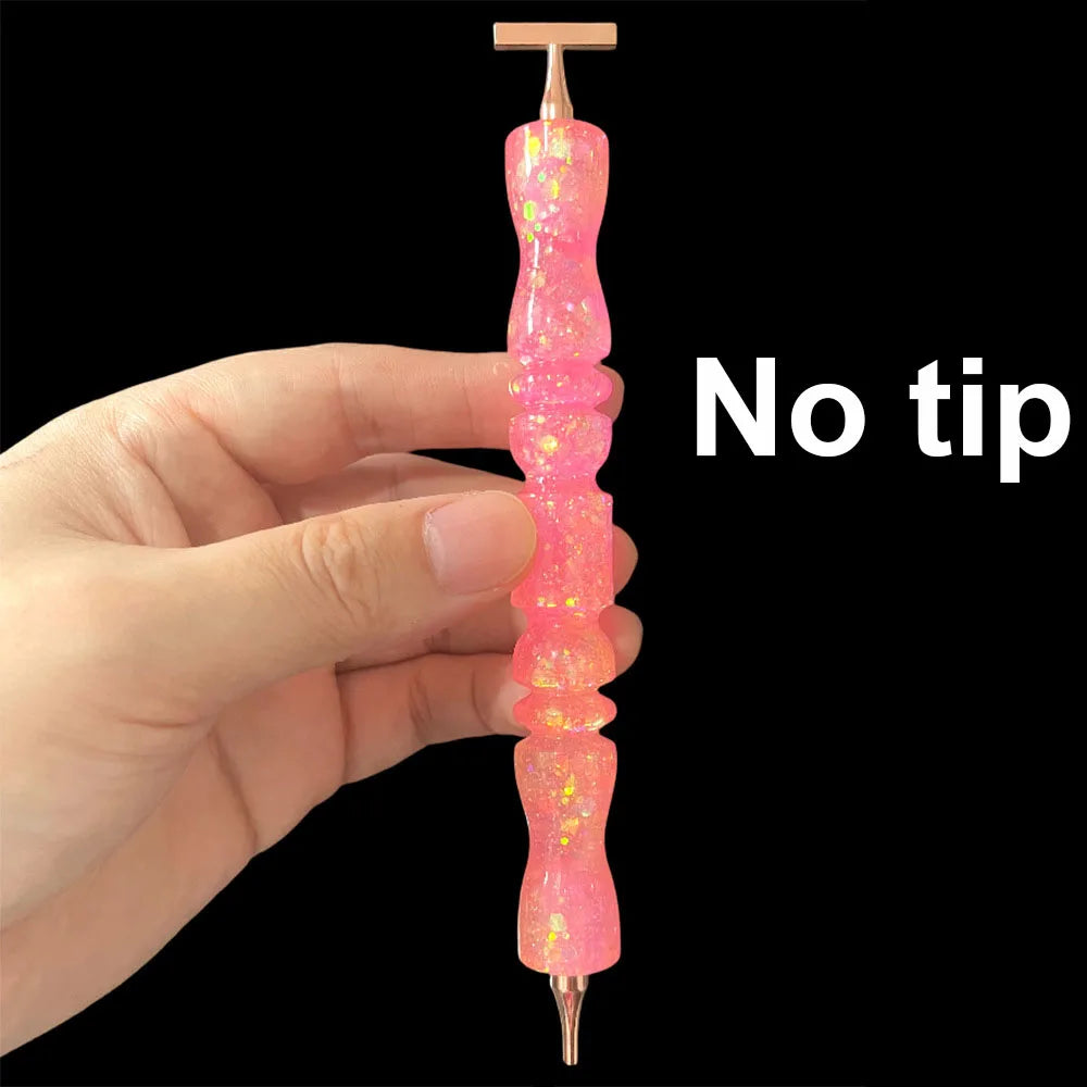 A hand holds a glitter resin diamond painting pen with a sparkle wavy handle, showing the product's design.