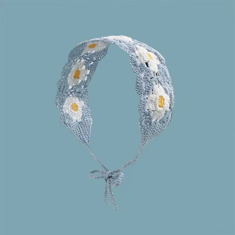 A light blue and white floral crochet headband with a wide elastic band.