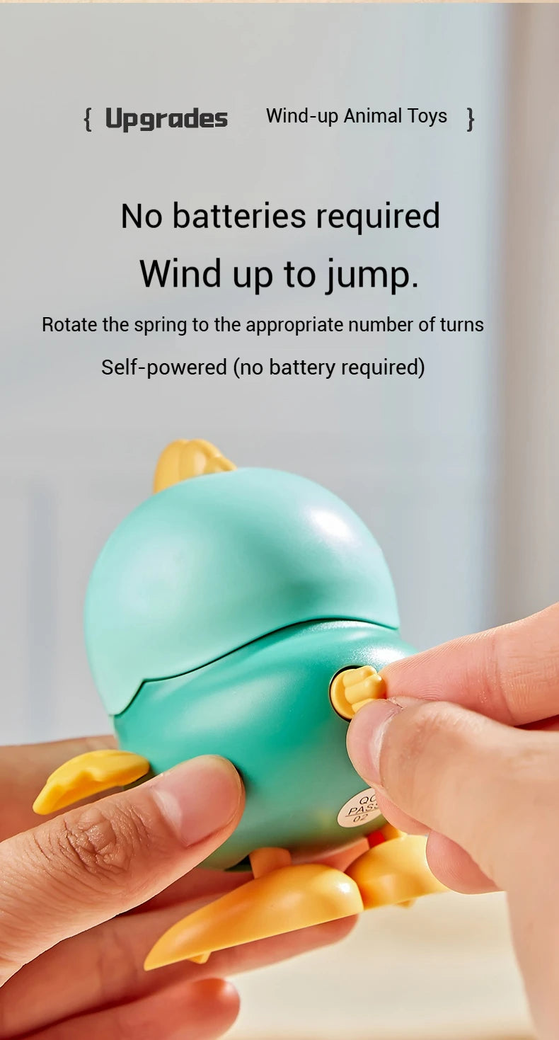 Hands are rotating the spring of a teal wind-up animal toy to make it jump.