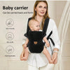 A woman is carrying a baby in a black ergonomic baby carrier, demonstrating its use.