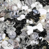 A close-up view of mixed clear and colored acrylic loose beads for jewelry making, including white, black, and iridescent pie