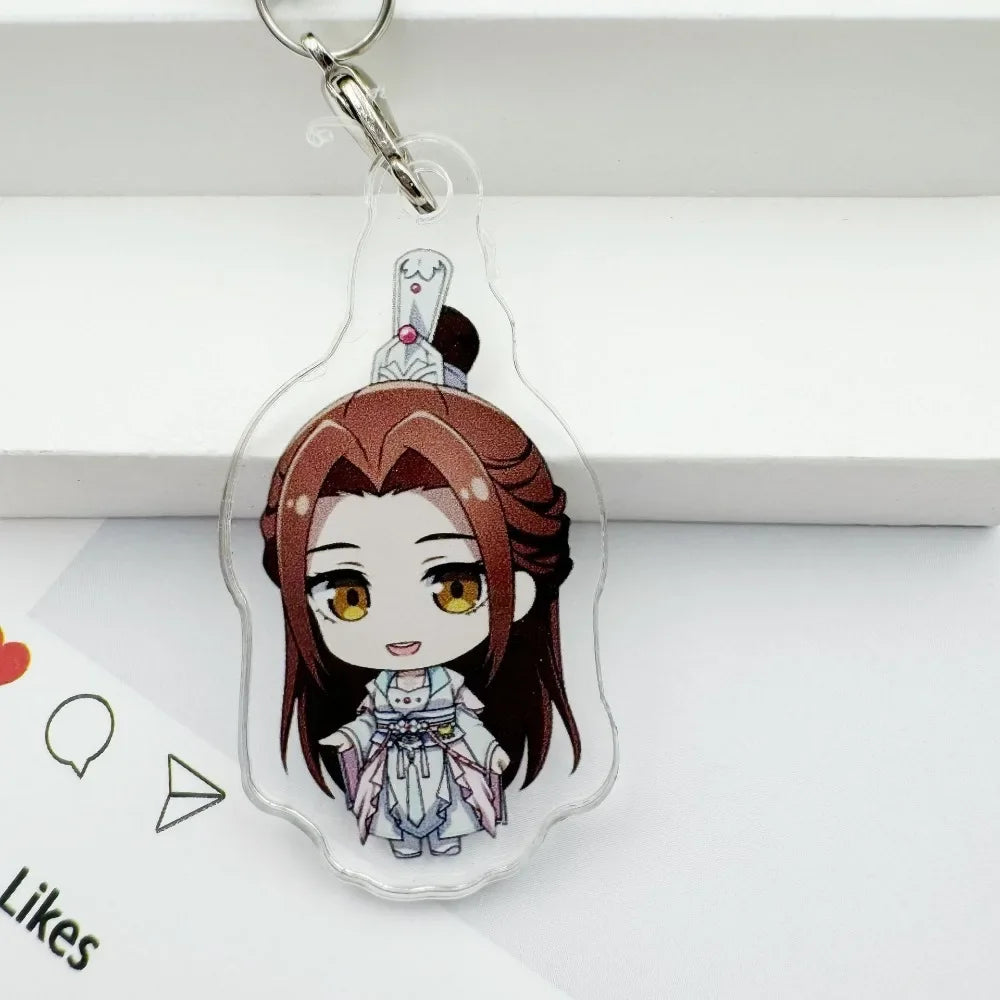 A clear acrylic pendant featuring an anime-style character with brown hair and yellow eyes, attached to a silver keychain.